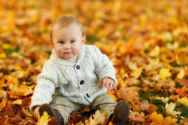 bébé assis dans les feuilles